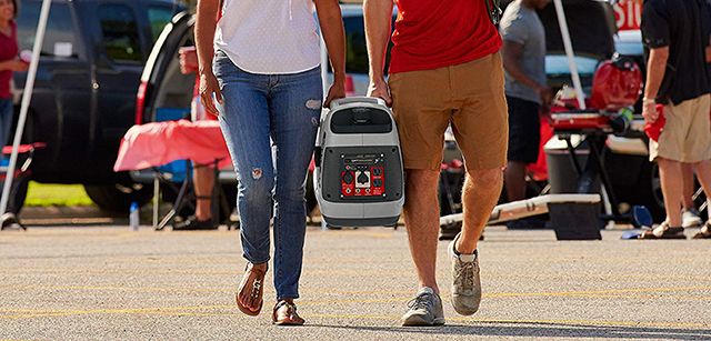 Two people carrying generator