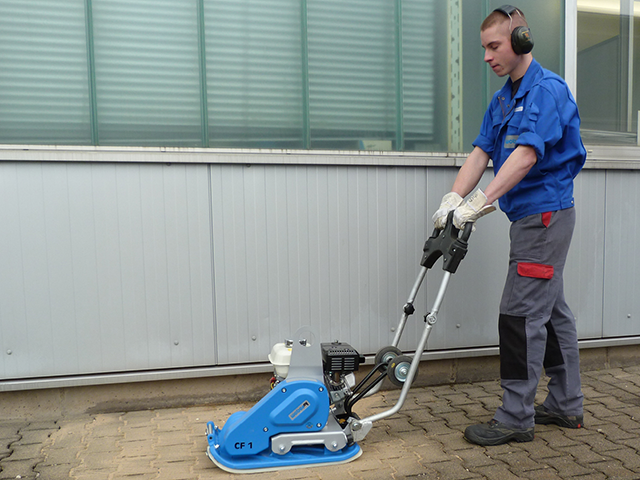 person pushing a compactor