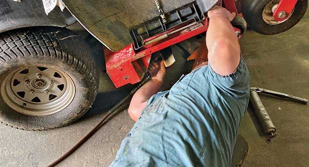 Person repairing zero turn mower