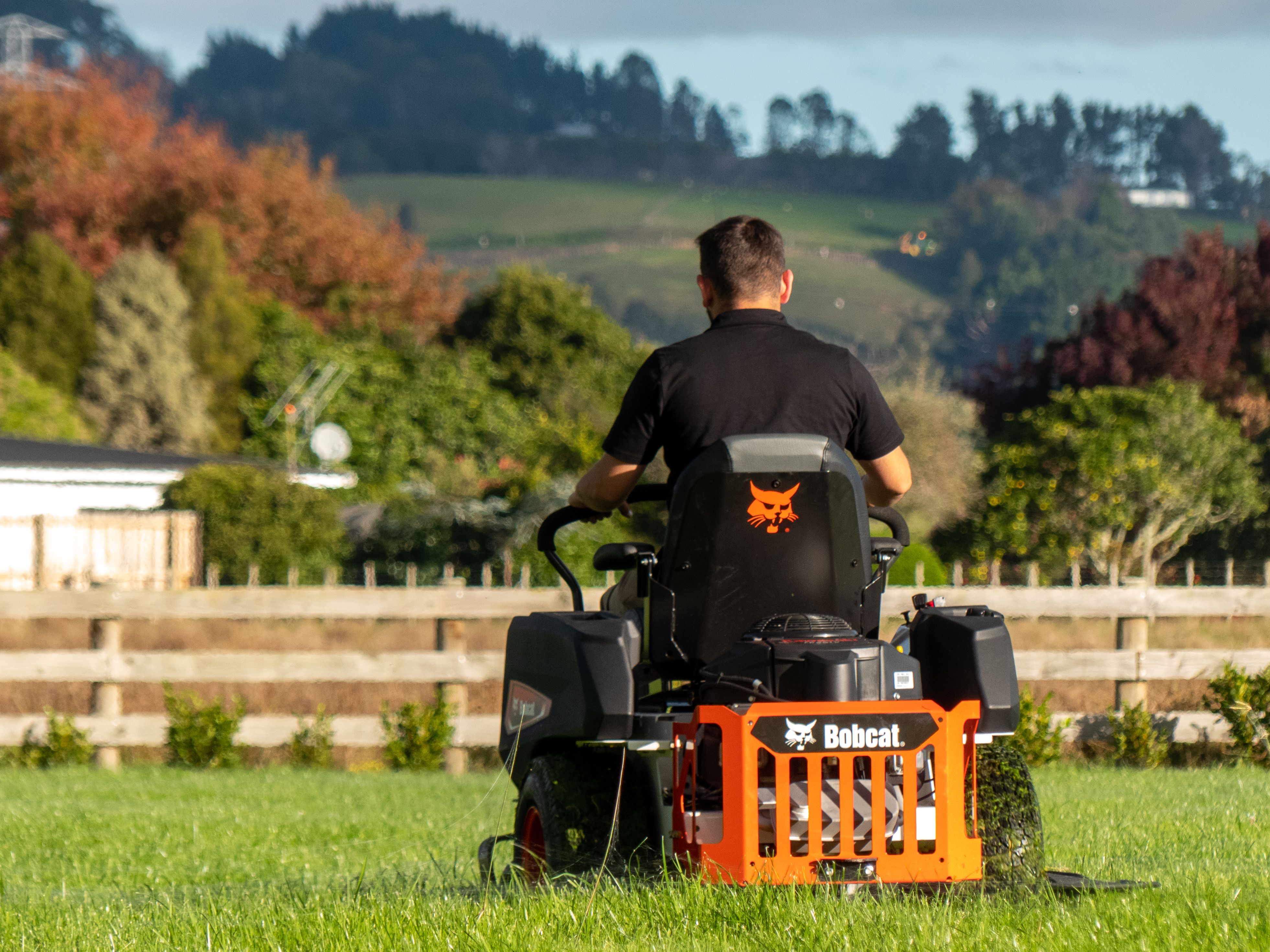 man riding on bobcat mower