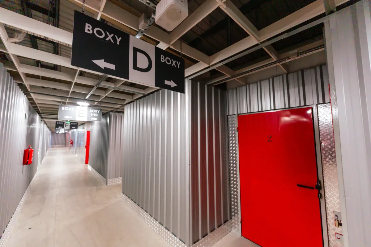 Korytarz magazynowy Celtic Self Storage Łomianki — oznakowanie BOXY D i czerwone drzwi