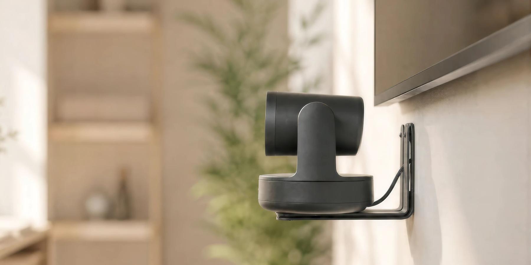 PTZ camera on a slim Heckler wall shelf mount beside a display.