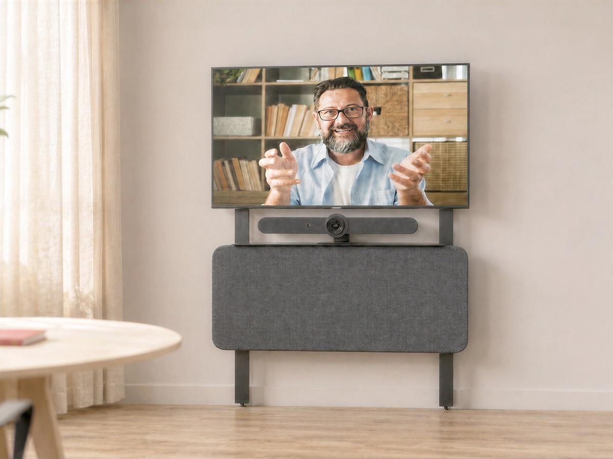 Fabric-wrapped AV hub below a display in a meeting room.