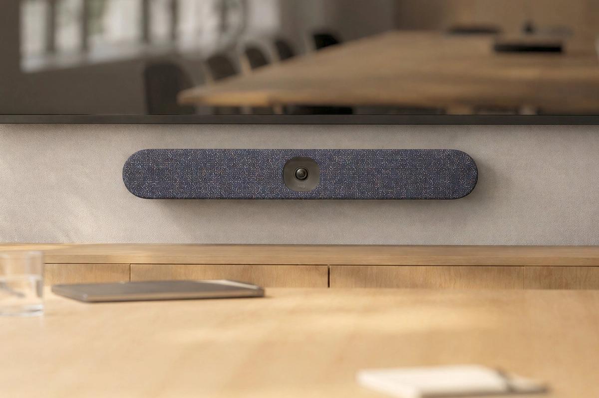 Custom textile cover for Logitech Rally Bar Huddle in a meeting room.