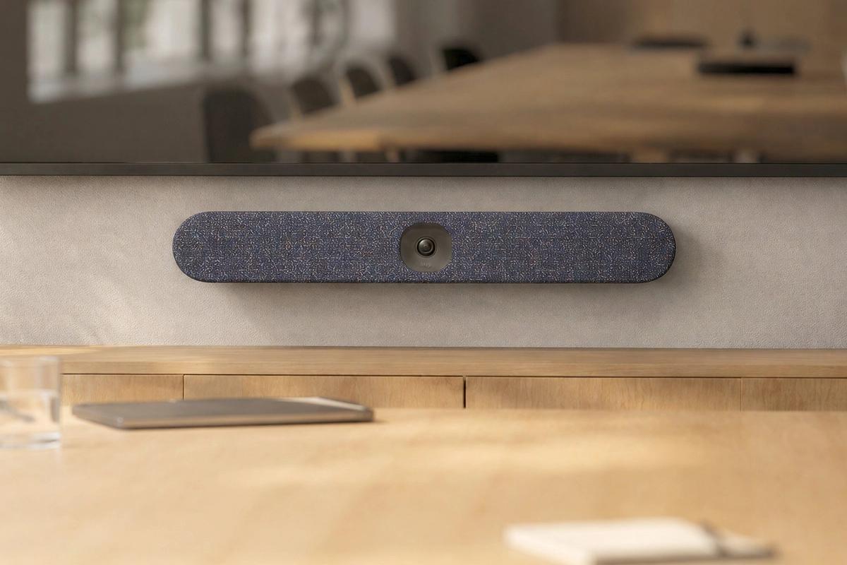 Custom textile cover for Logitech Rally Bar Huddle in a meeting room.