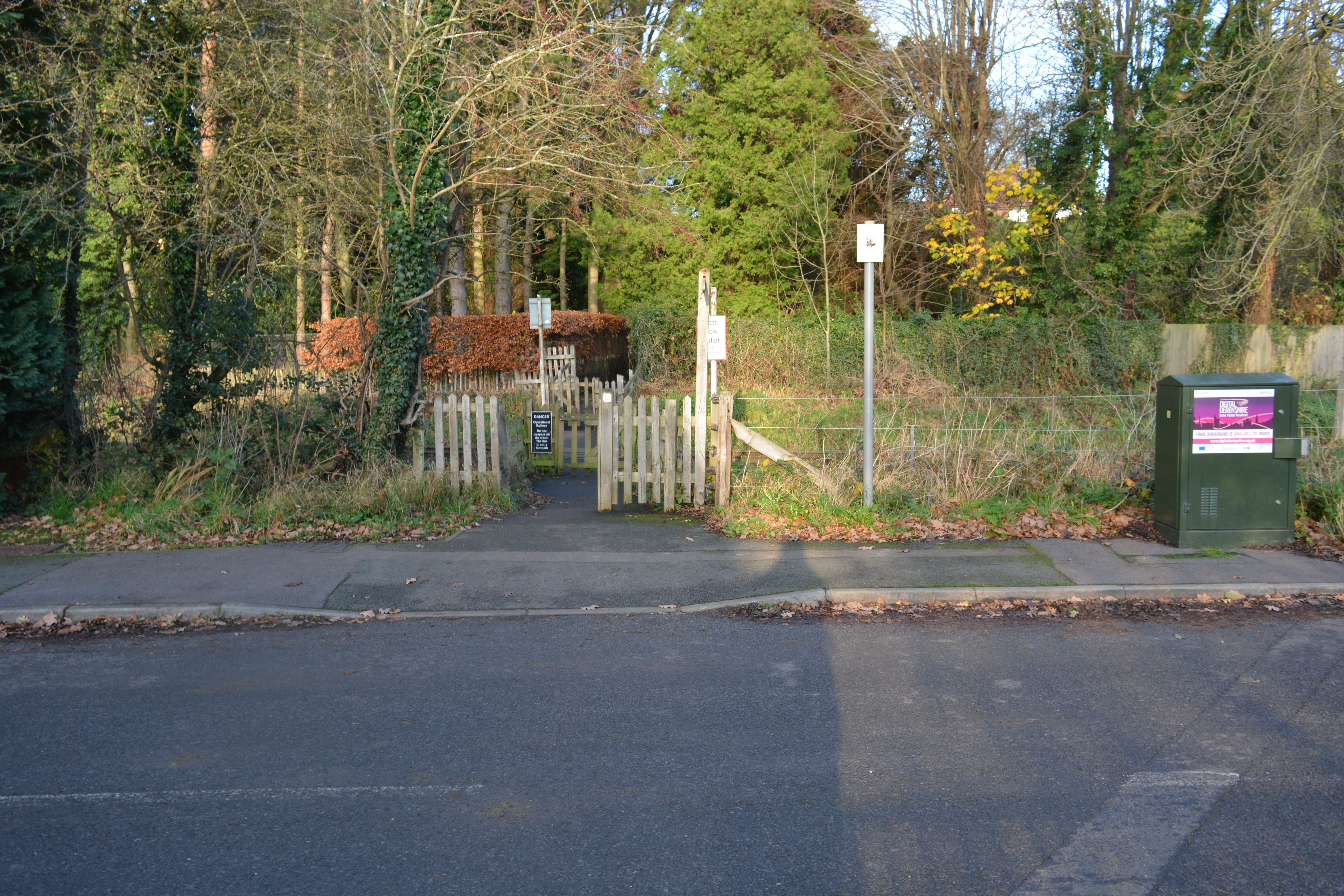 Gated crossing of Ecclesbourne Valley Railway tracks