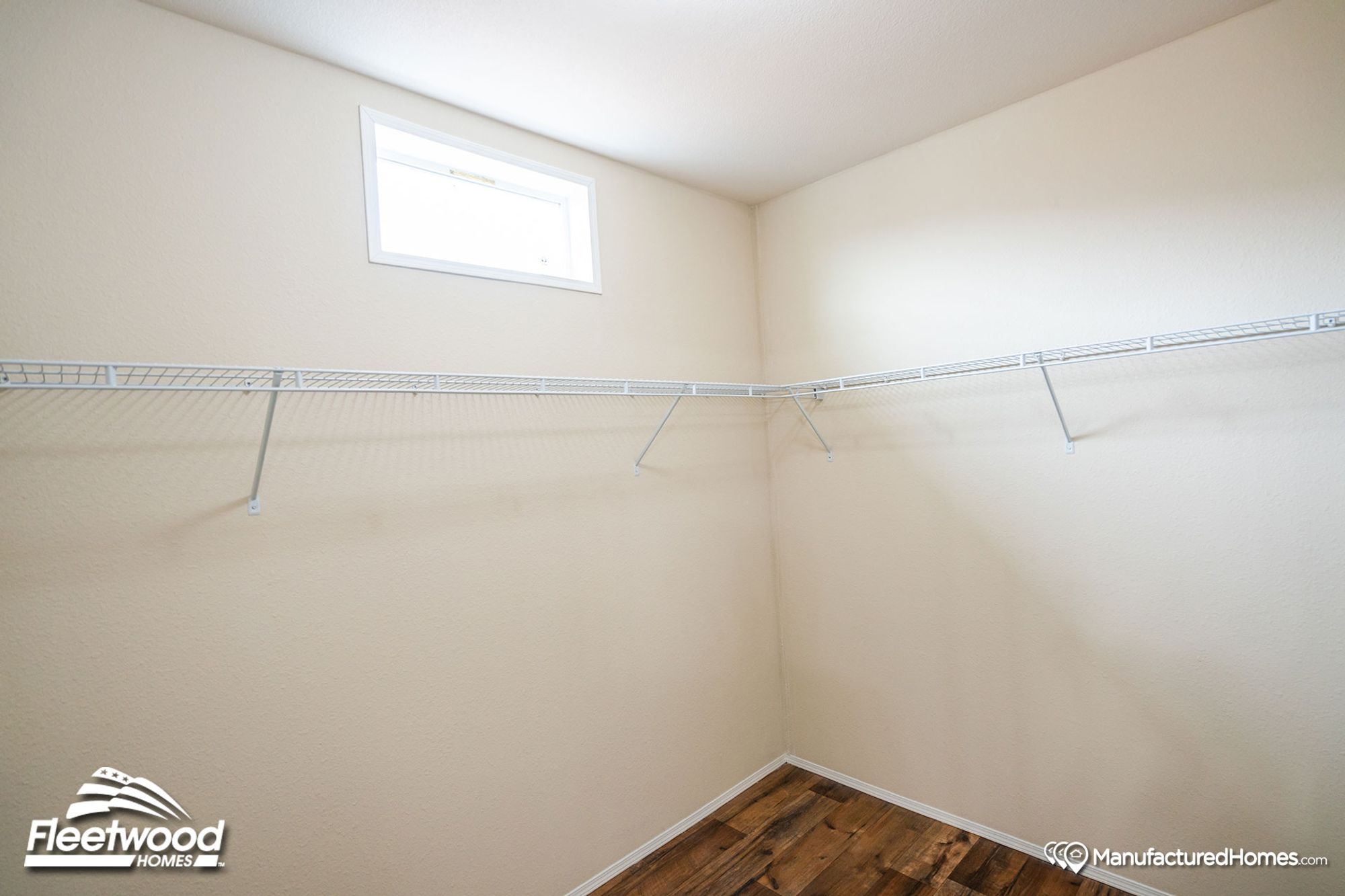 Large walk-in closet with white shelving lining the walls.