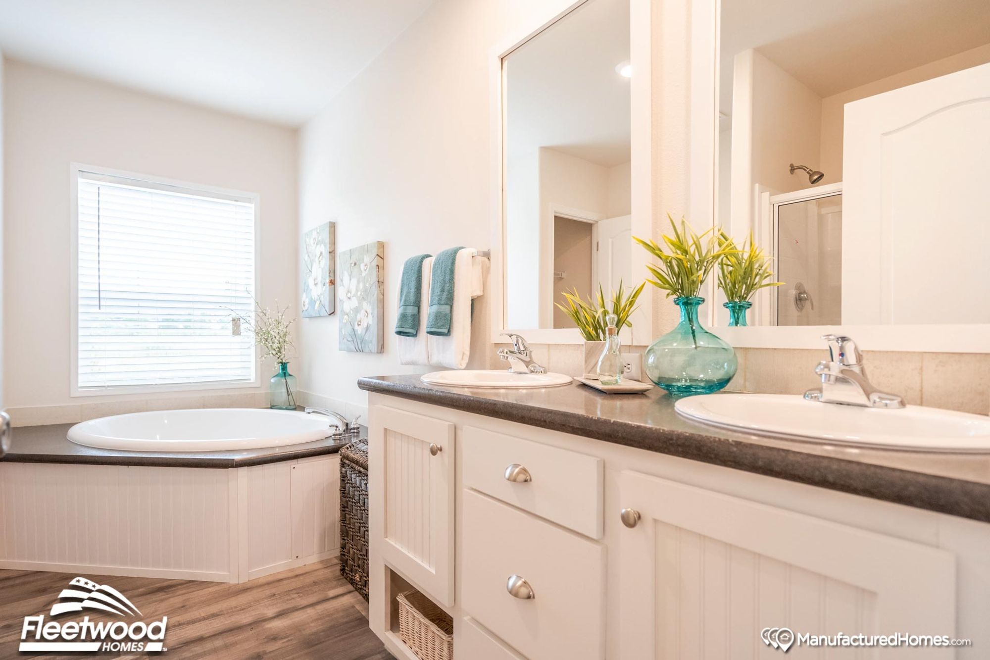 Partial view of the bathroom with a large bathtub and a double-sink countertop.