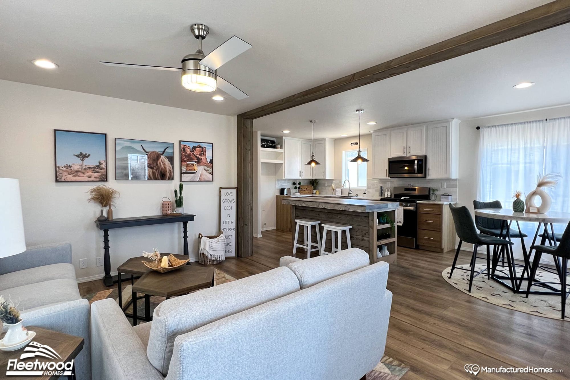 Open concept living room, kitchen, and living room. The living room is a mid-sized room with two couches, a coffee table, a side table, and two chairs in the background.
