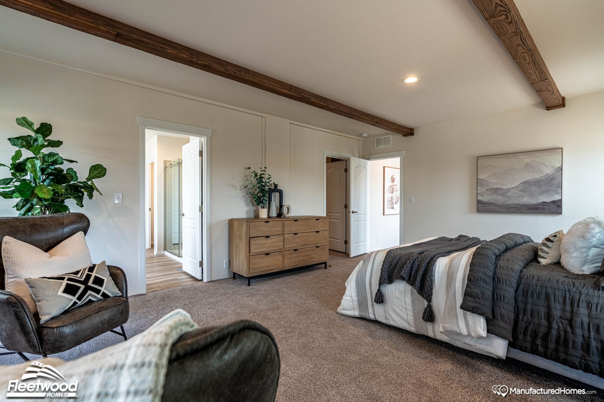 Large bedroom with two chairs and a large bed.