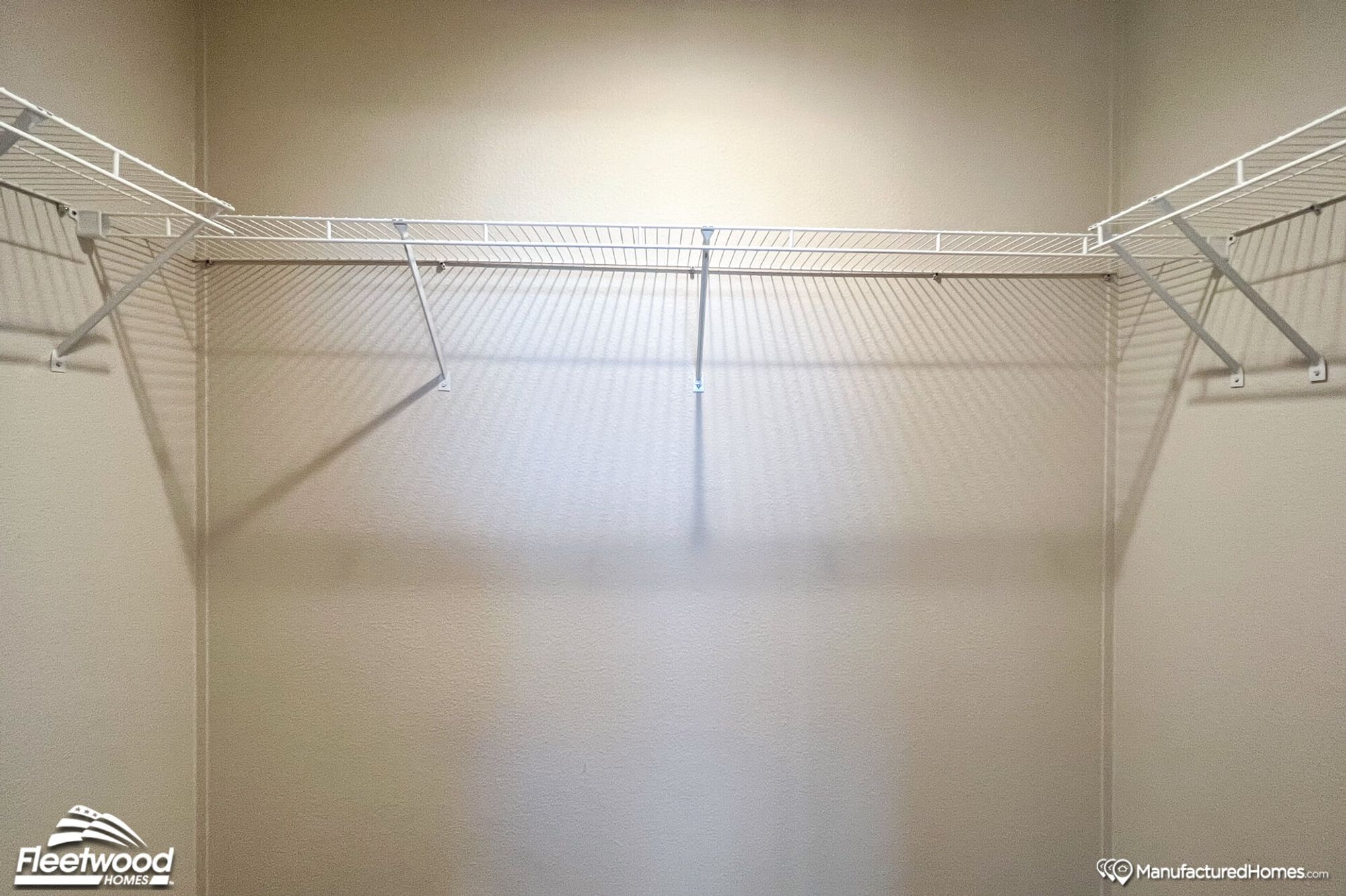 Large walk-in closet with white shelving lining the walls.
