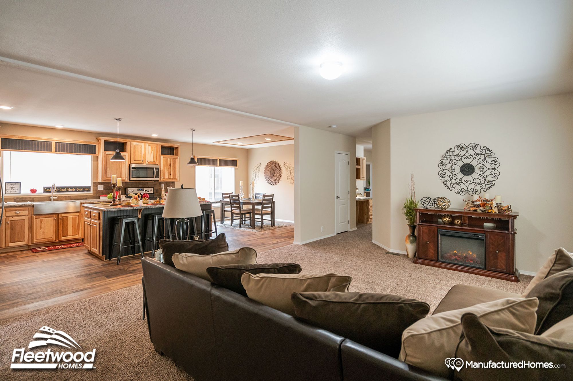 Large open front room with a large couch, a side table, and a fire place.
