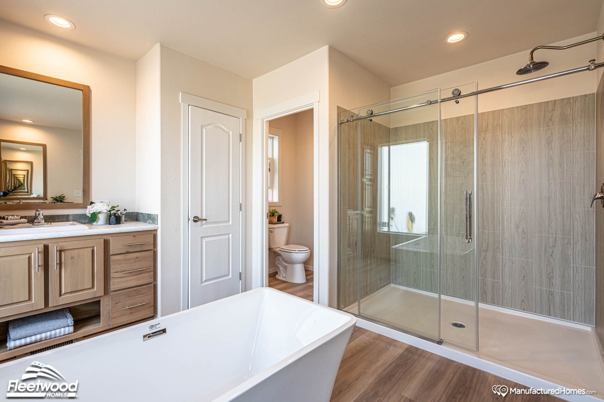 Large bathroom with a bathtub and a large standing shower.