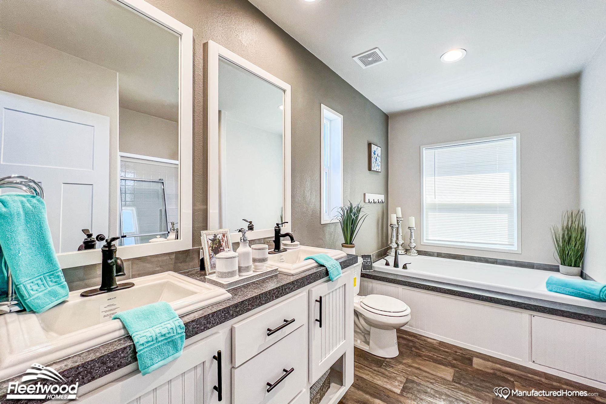 Close-up of a bathroom with a large bathtub and a spacious double-sink countertop.