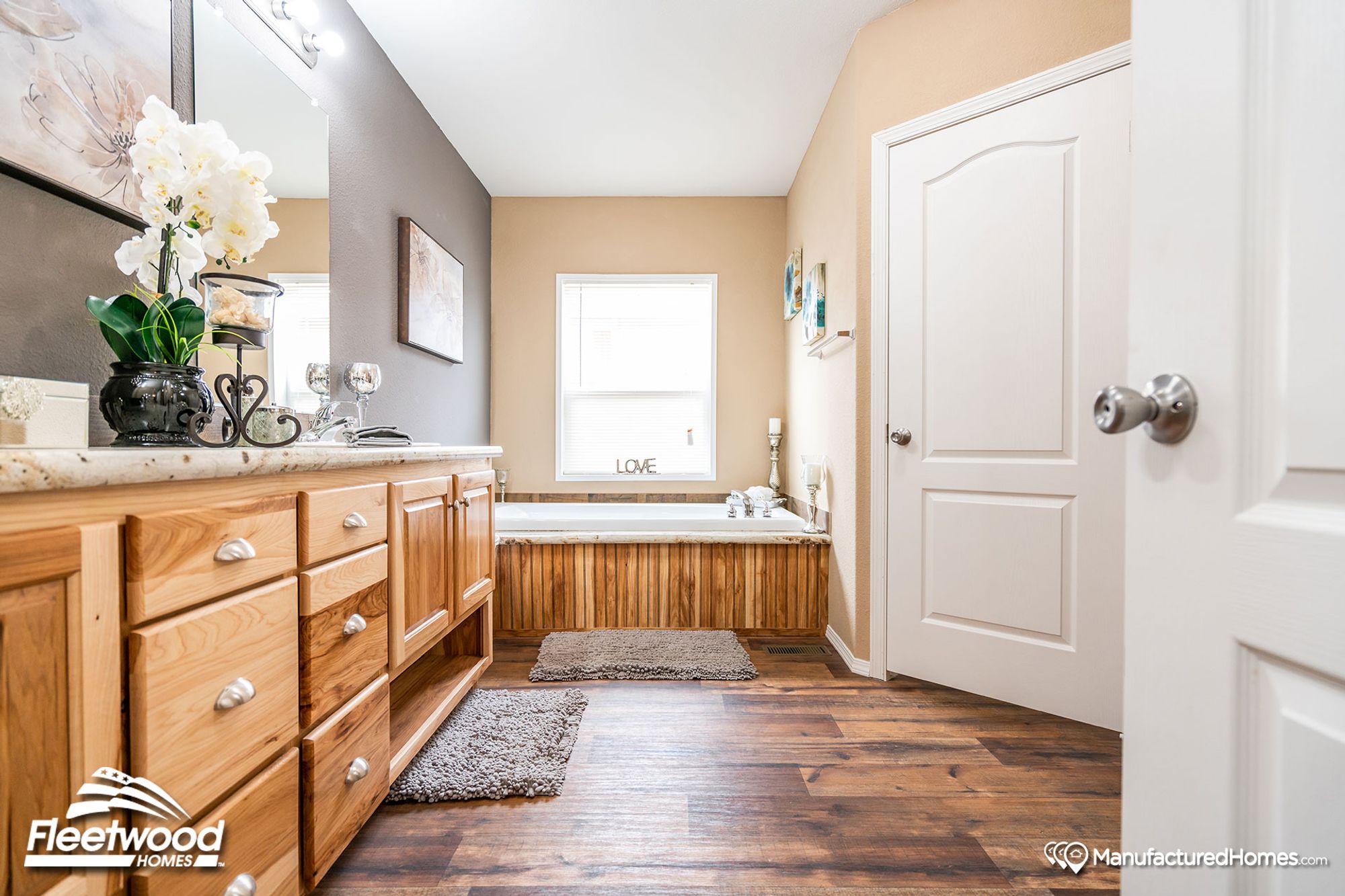 Mid-sized bathroom with a large bathtub and a countertop with a single sink.