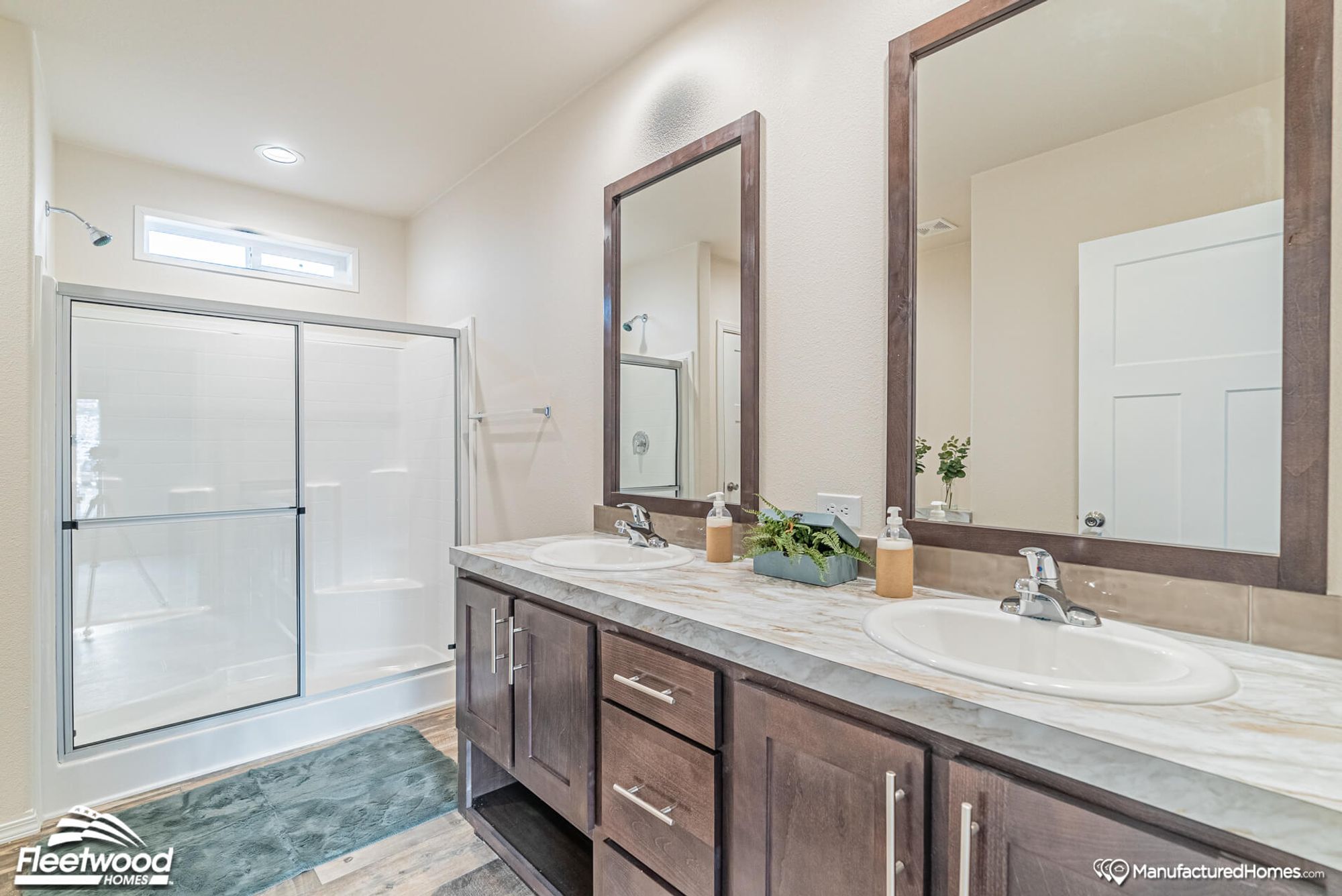 Large bathroom with a double sink counter top and a large standing shower.