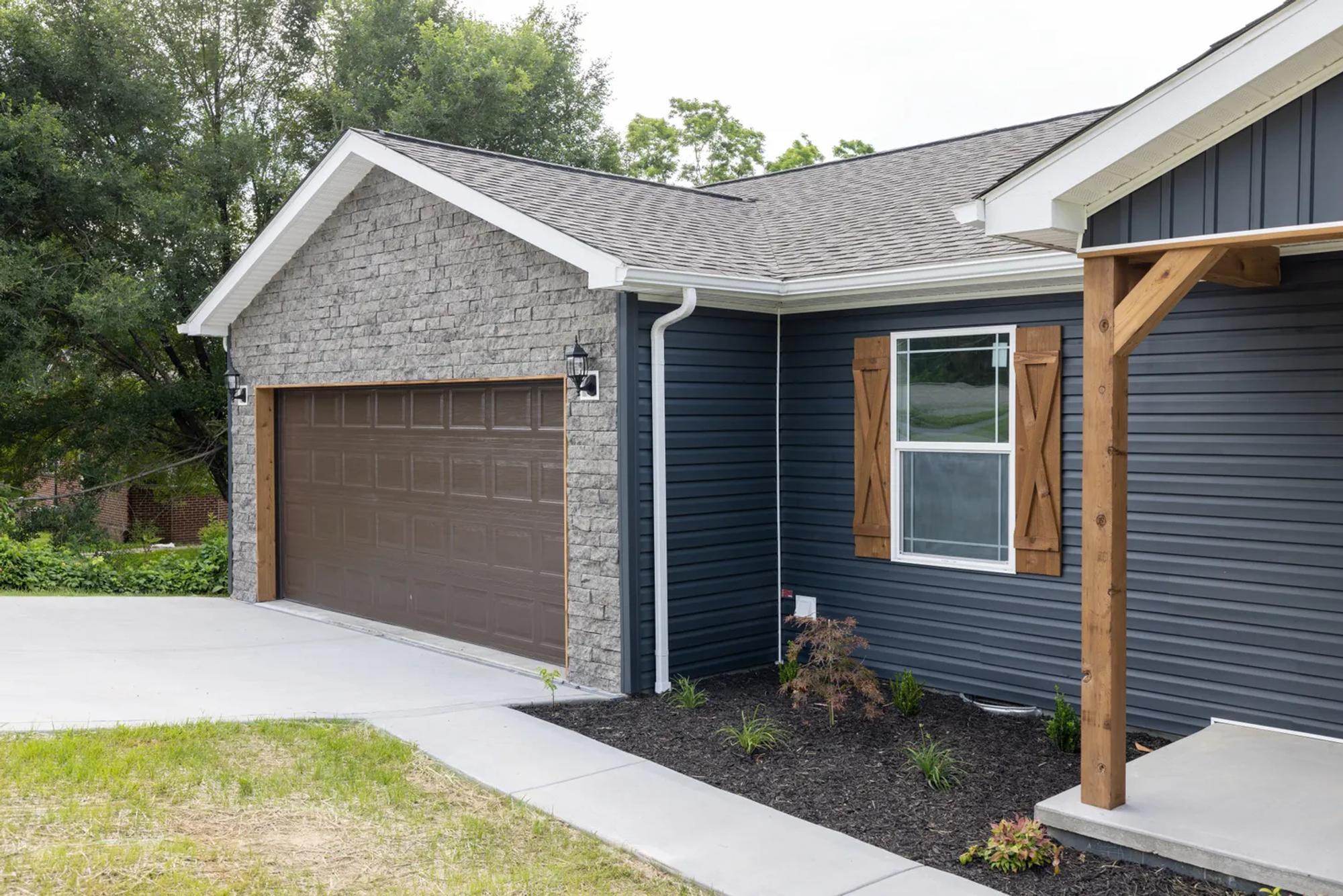 Partial view of blue house, pointing towards the garage