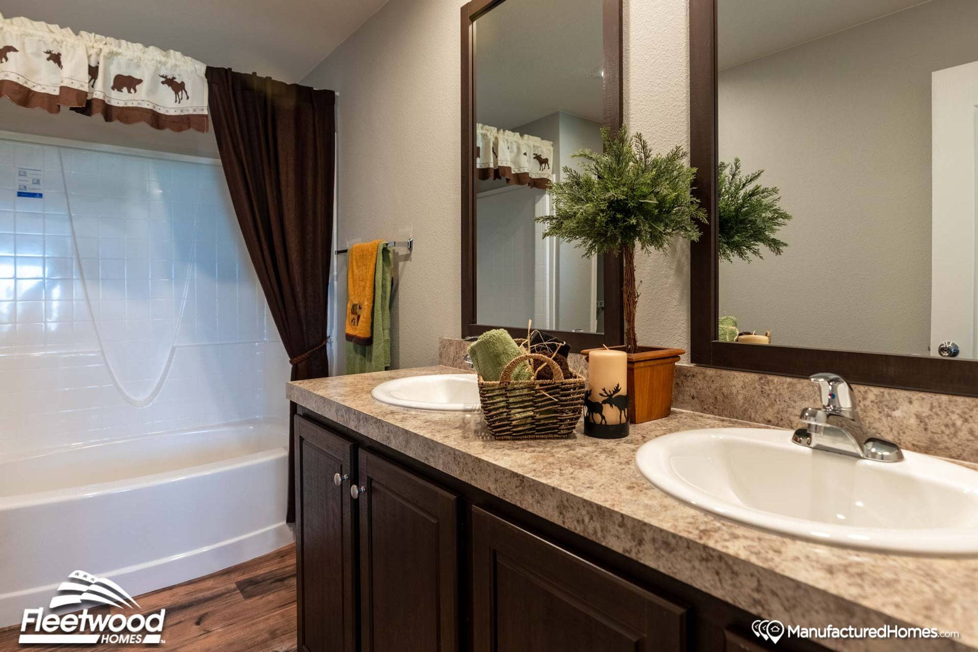 Mid-sized bathroom with a bathtub-shower combo and a double sink counter top.