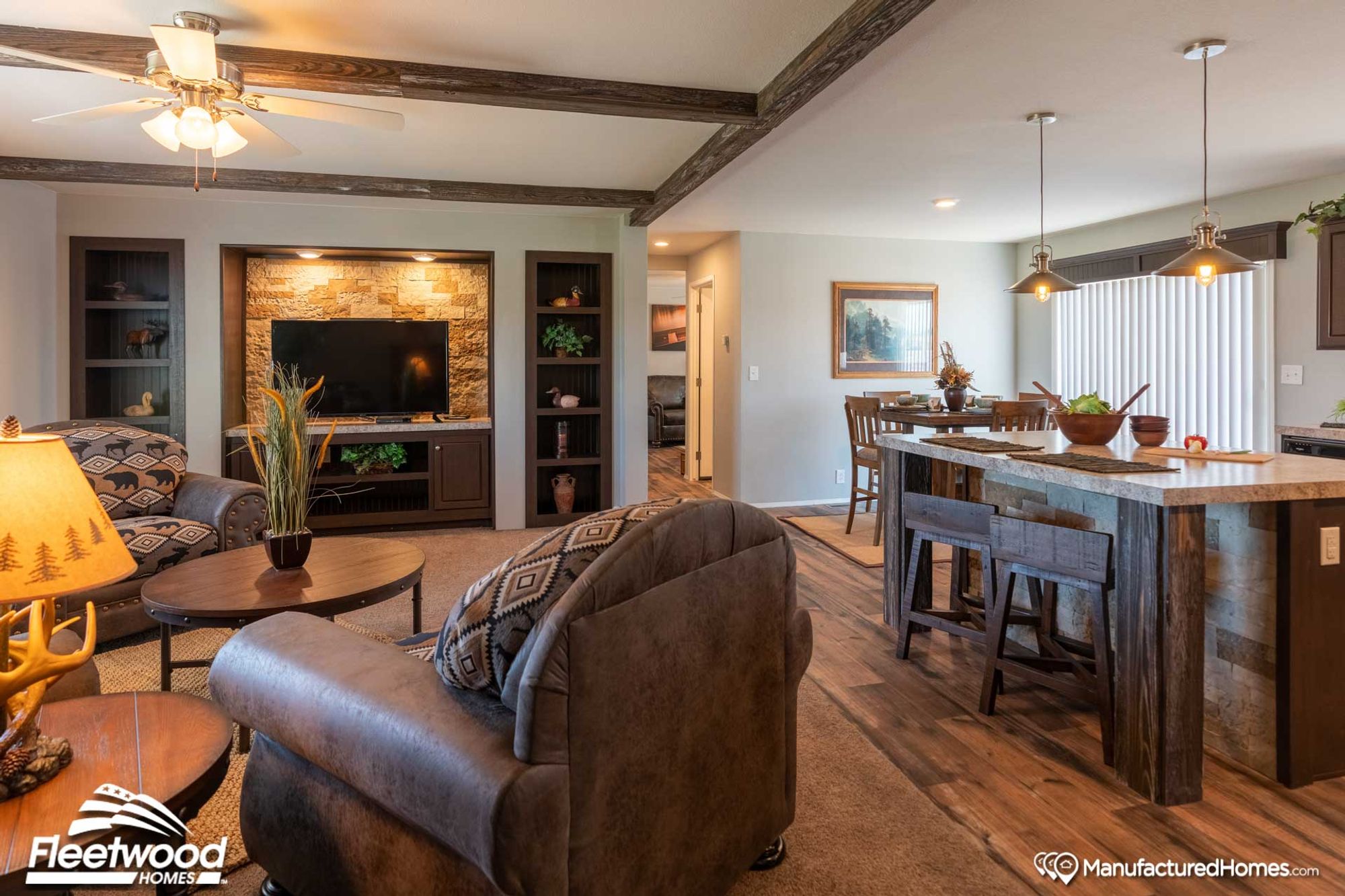 An open concept kitchen, living room, and dining room. The living room is mid-sized with three chairs, a coffee table, a side table, and a fireplace.