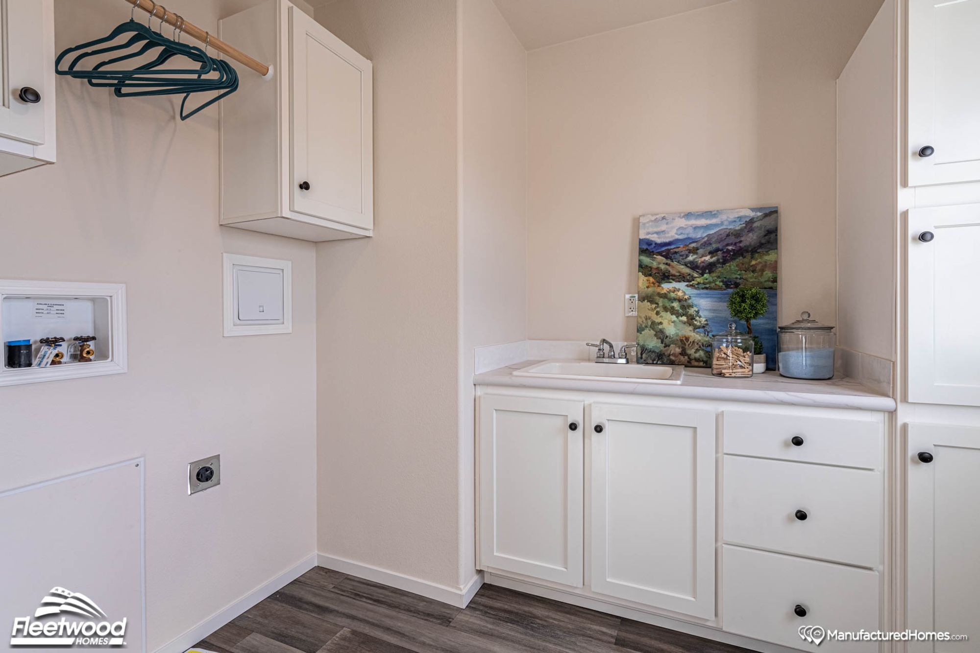 Side view of a laundry room showcasing a sink and the laundry hookups.
