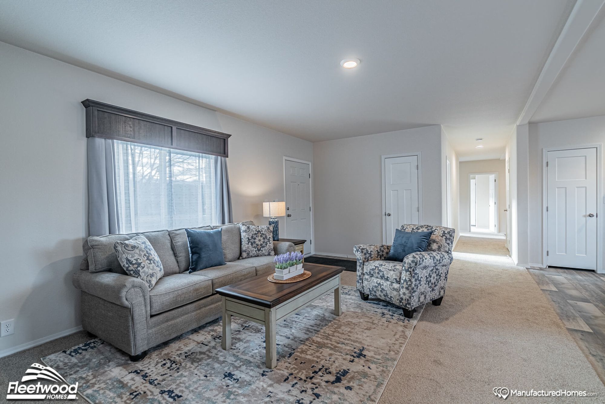Large living room with one couch and one chair and a coffee table