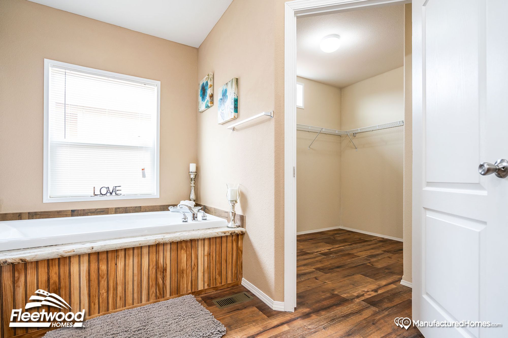 Close-up of a bathroom with a large bathtub and a view of a walk-in closet.