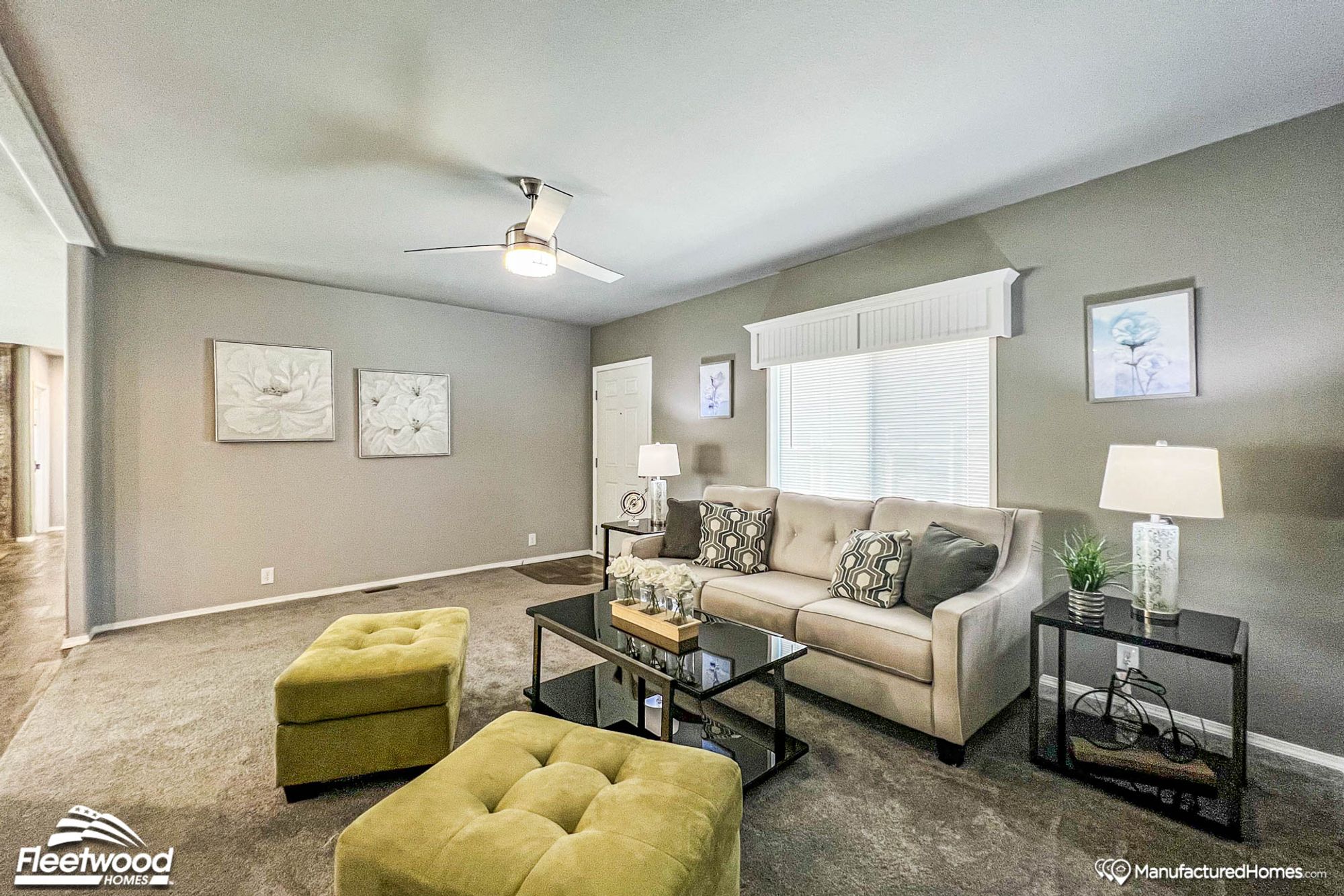 Large front room with a couch and two ottomans.