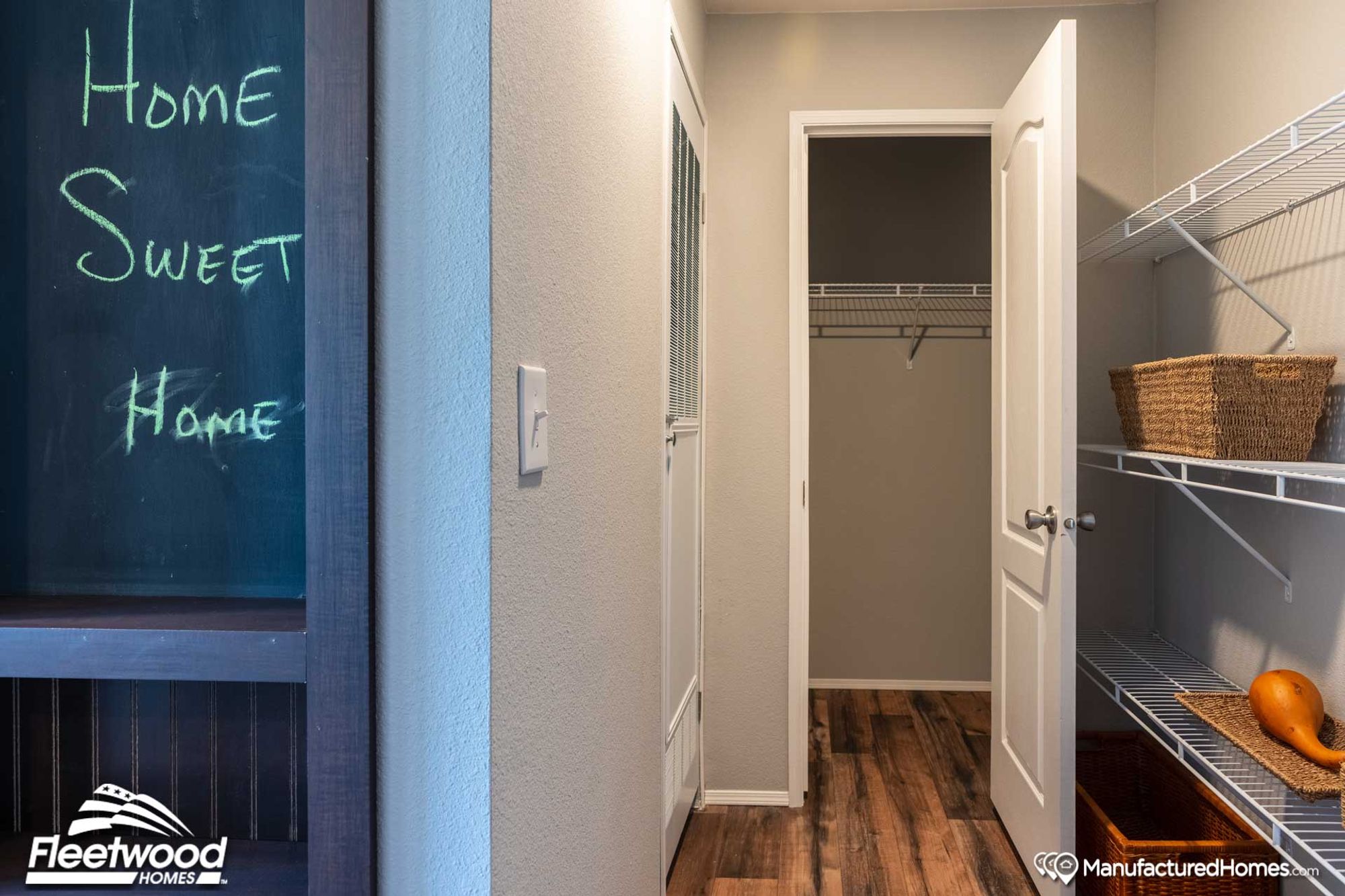 Hallway with built-in wall shelves and a partial view into a spacious closet.