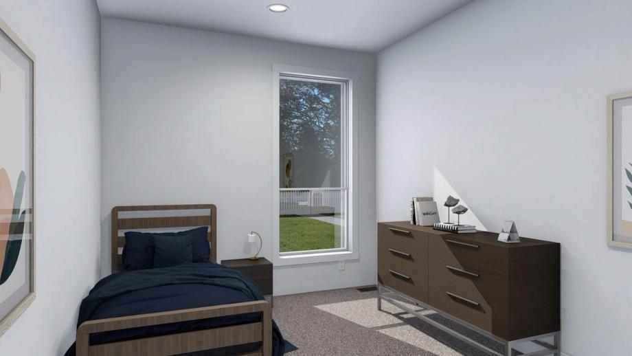 A medium-sized bedroom with a single bed, a dresser, and a side table.