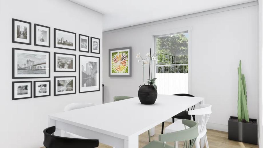 Midsized dining area with a white table that seats six, accented by a gallery wall of framed photos.