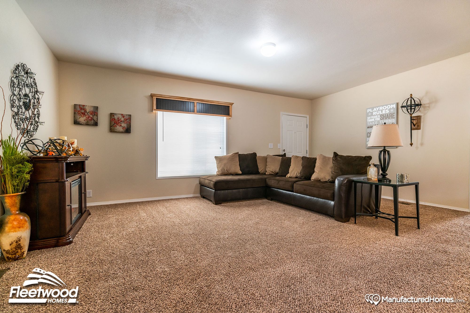 Large open front room with a large couch and a side table.