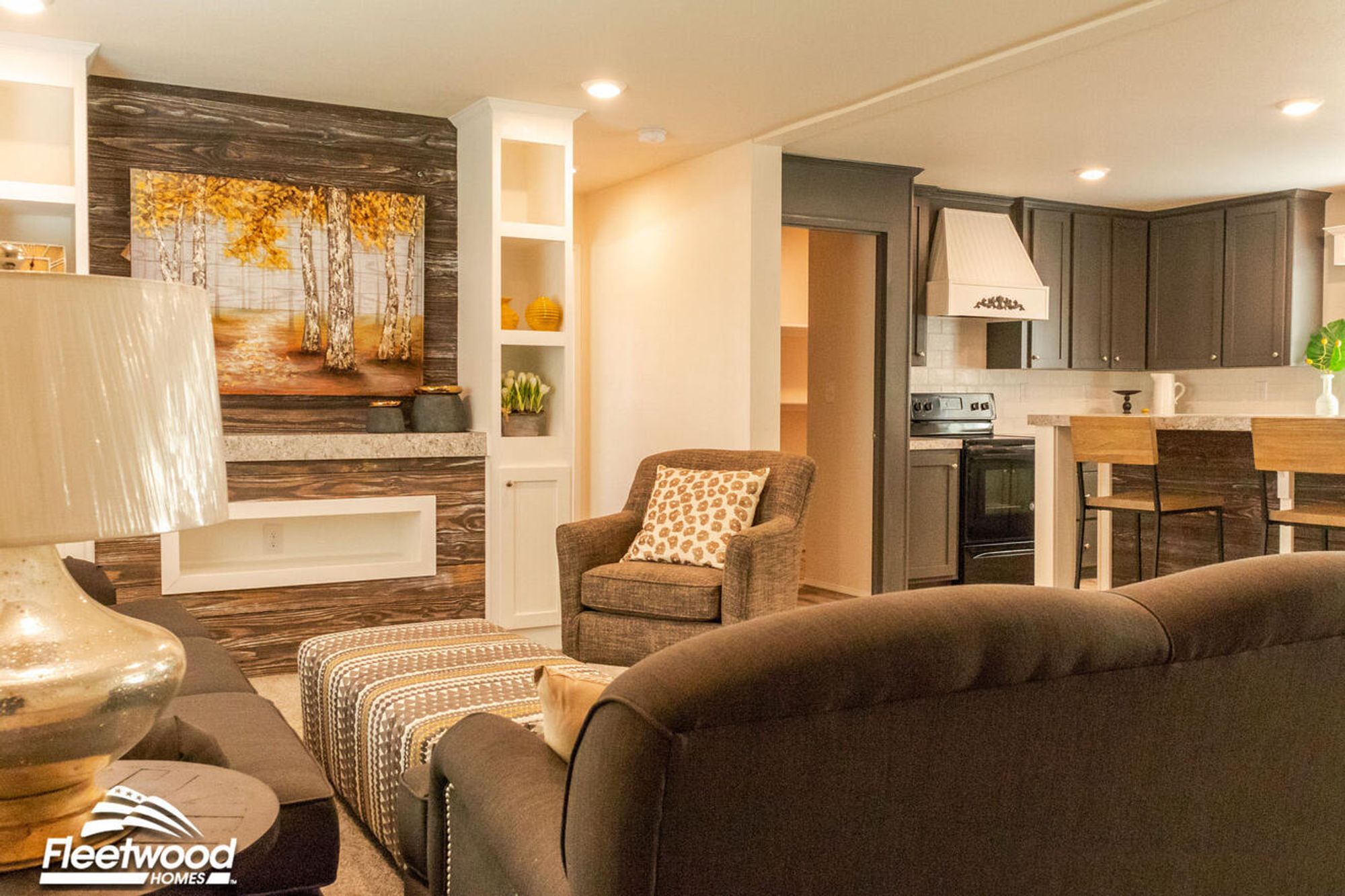 Feature wall with rustic wood paneling and a birch tree painting, framed by white built-in shelves displaying modern yellow and neutral decor accents.