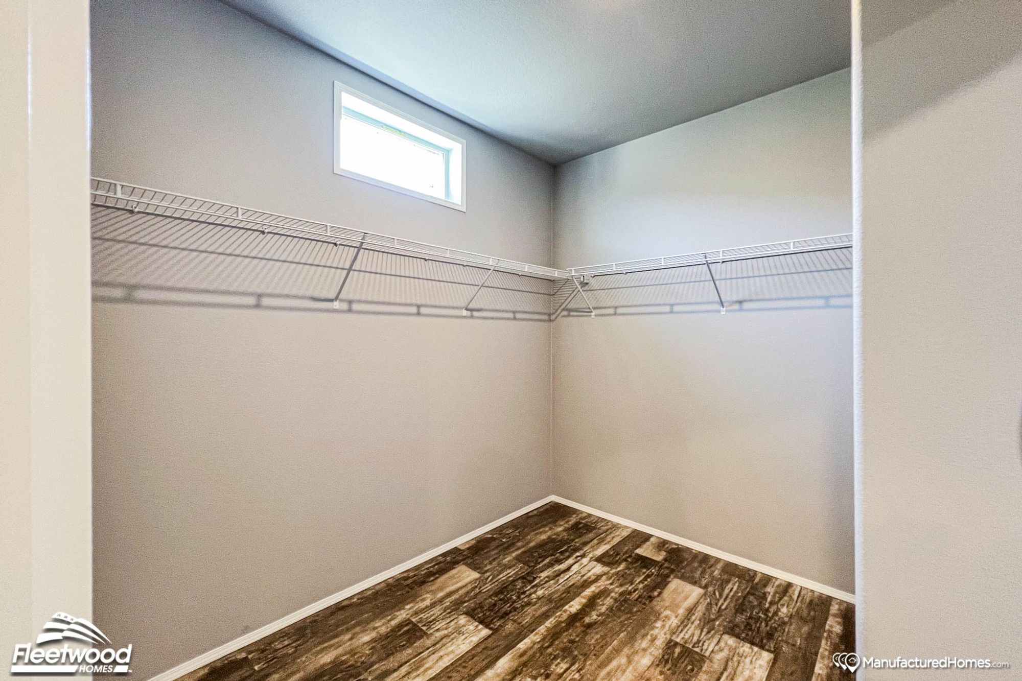 Large empty walk-in closet with wall-to-wall high shelving.