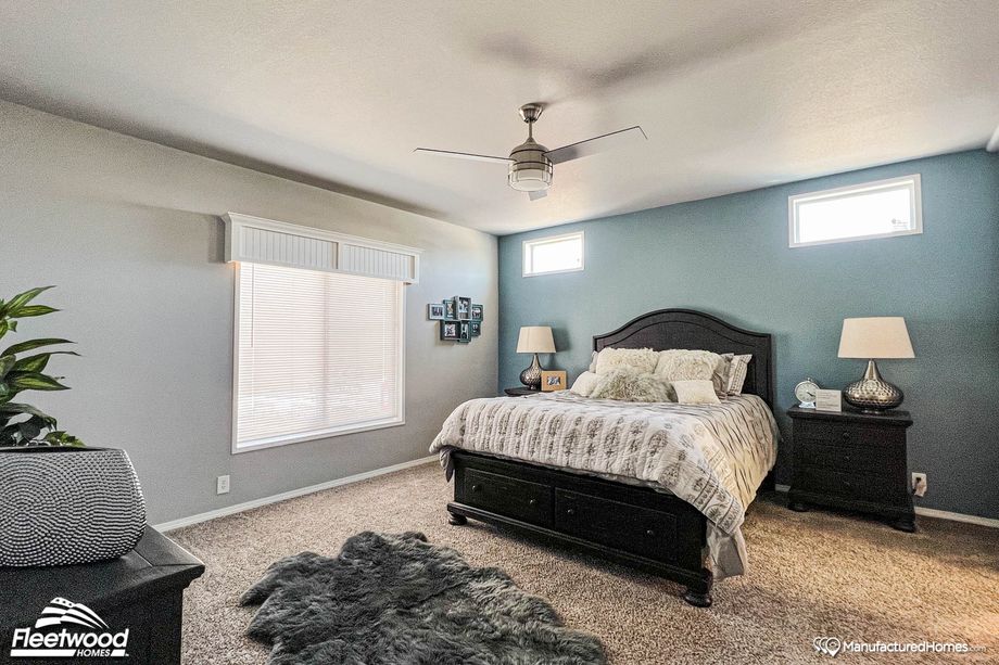 Large bedroom with a full bed, two side tables, and a connected bathroom.