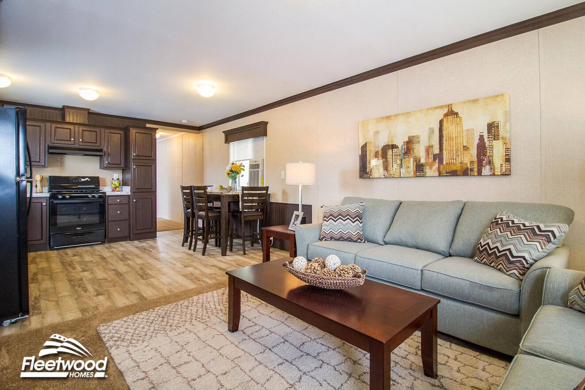 Cozy living room with beige walls, sofa set, coffee table, lamps, and window by the front door.