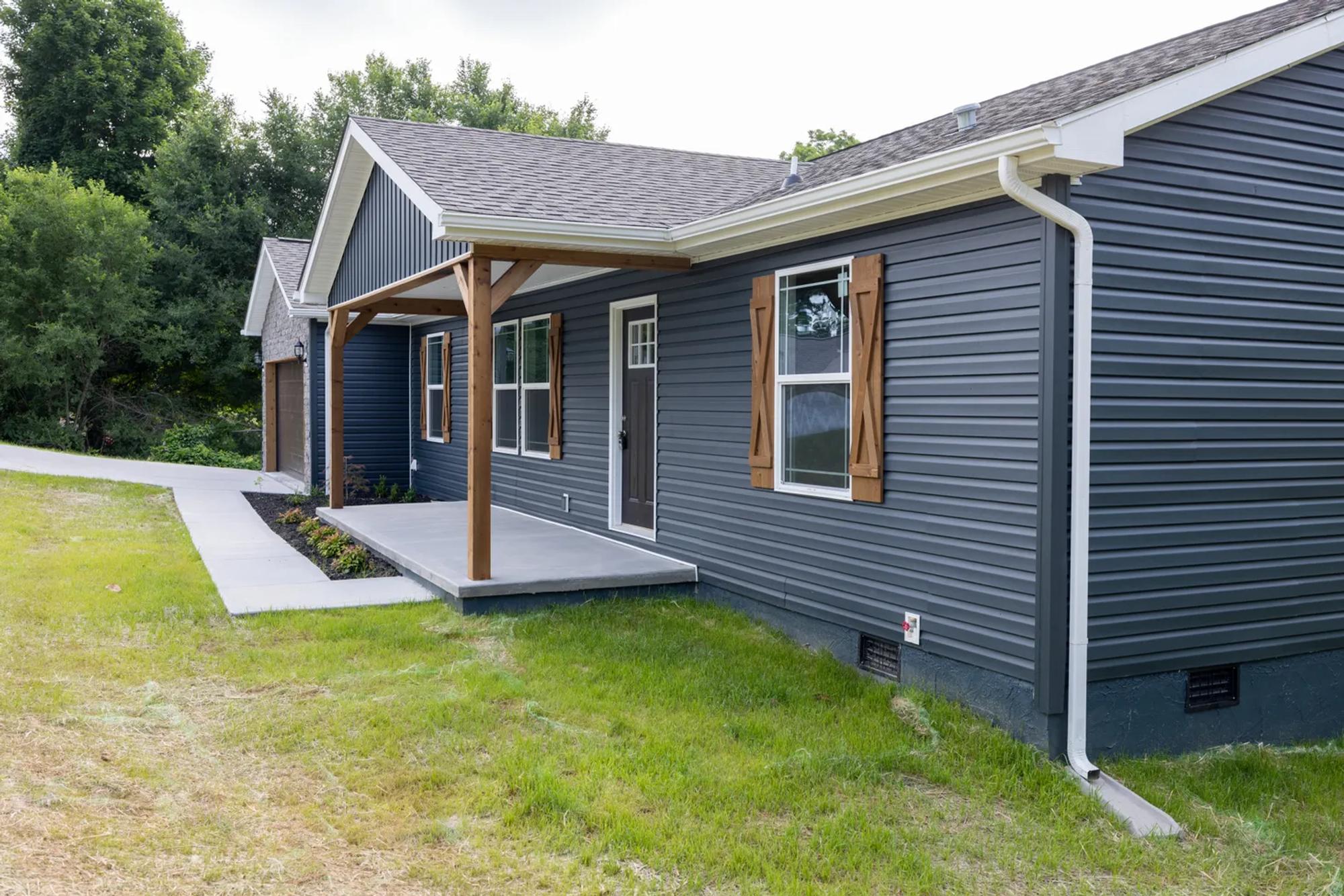 Side view of a blue house with wooden accents
