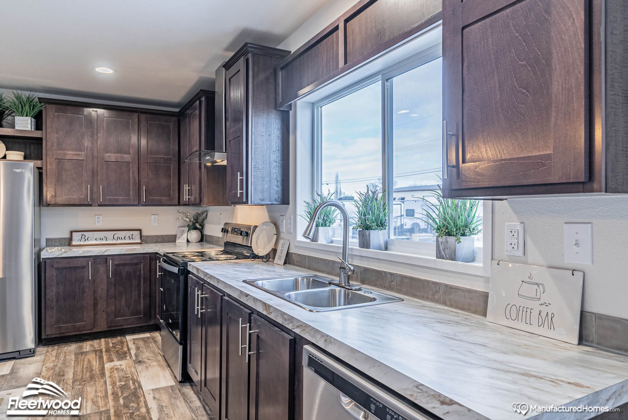 Close-up of a kitchen with brown cabinets, showcasing an oven and a sink.