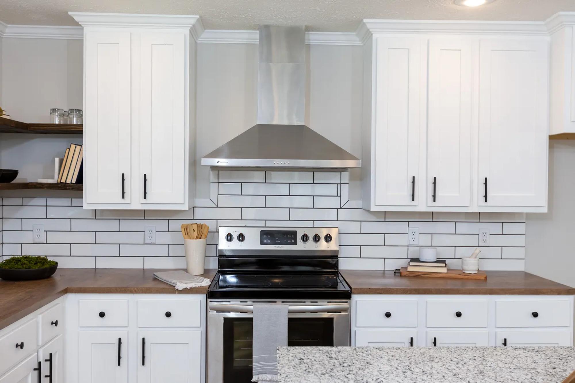 Close-up view of kitchen with brown countertops and white cabinets and drawers