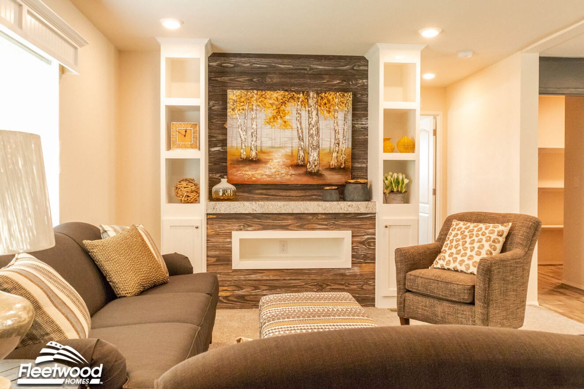 Feature wall with rustic wood paneling and a birch tree painting, framed by white built-in shelves displaying modern yellow and neutral decor accents.