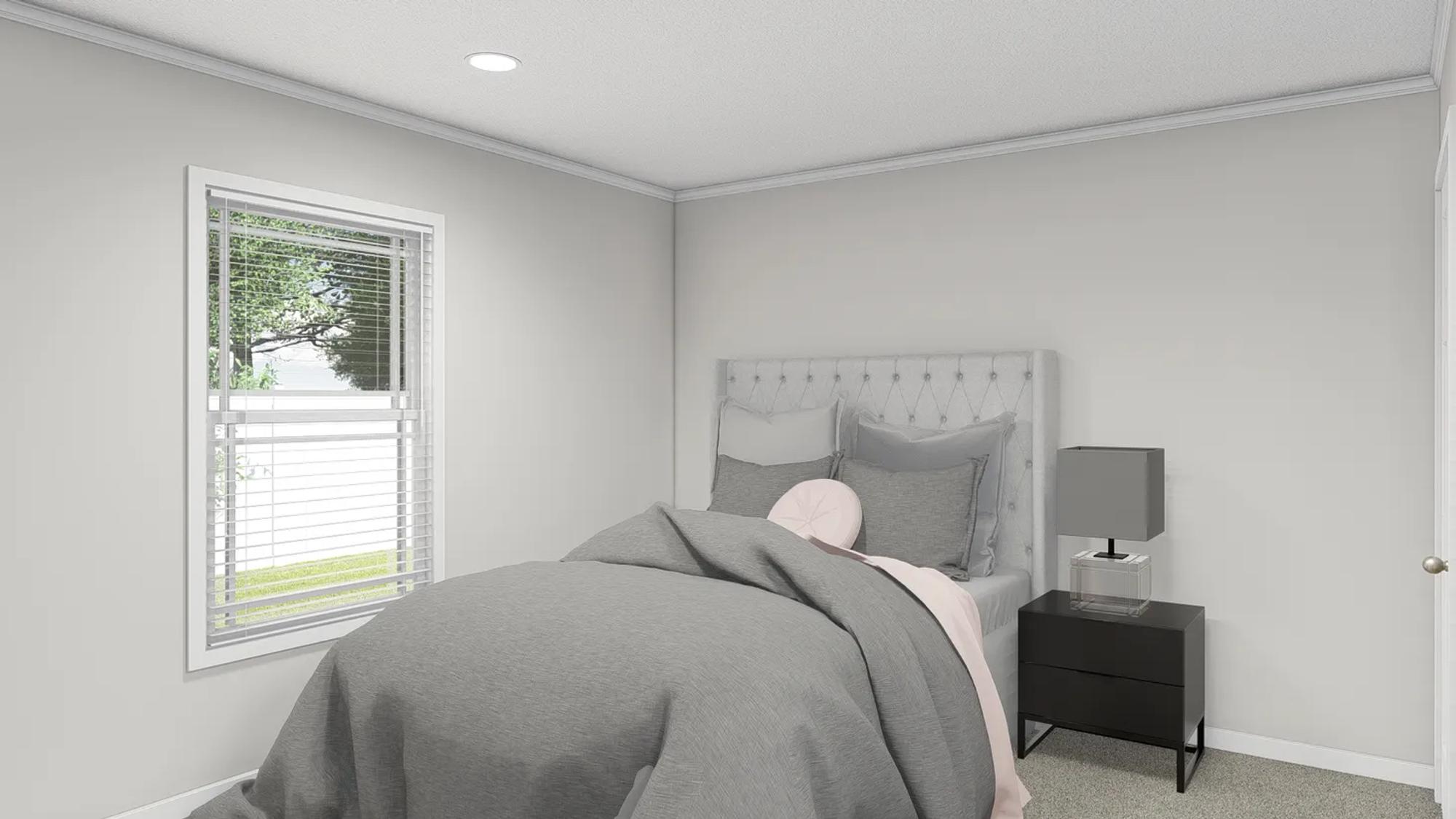Small bedroom with grey comforter and side table with grey lamp