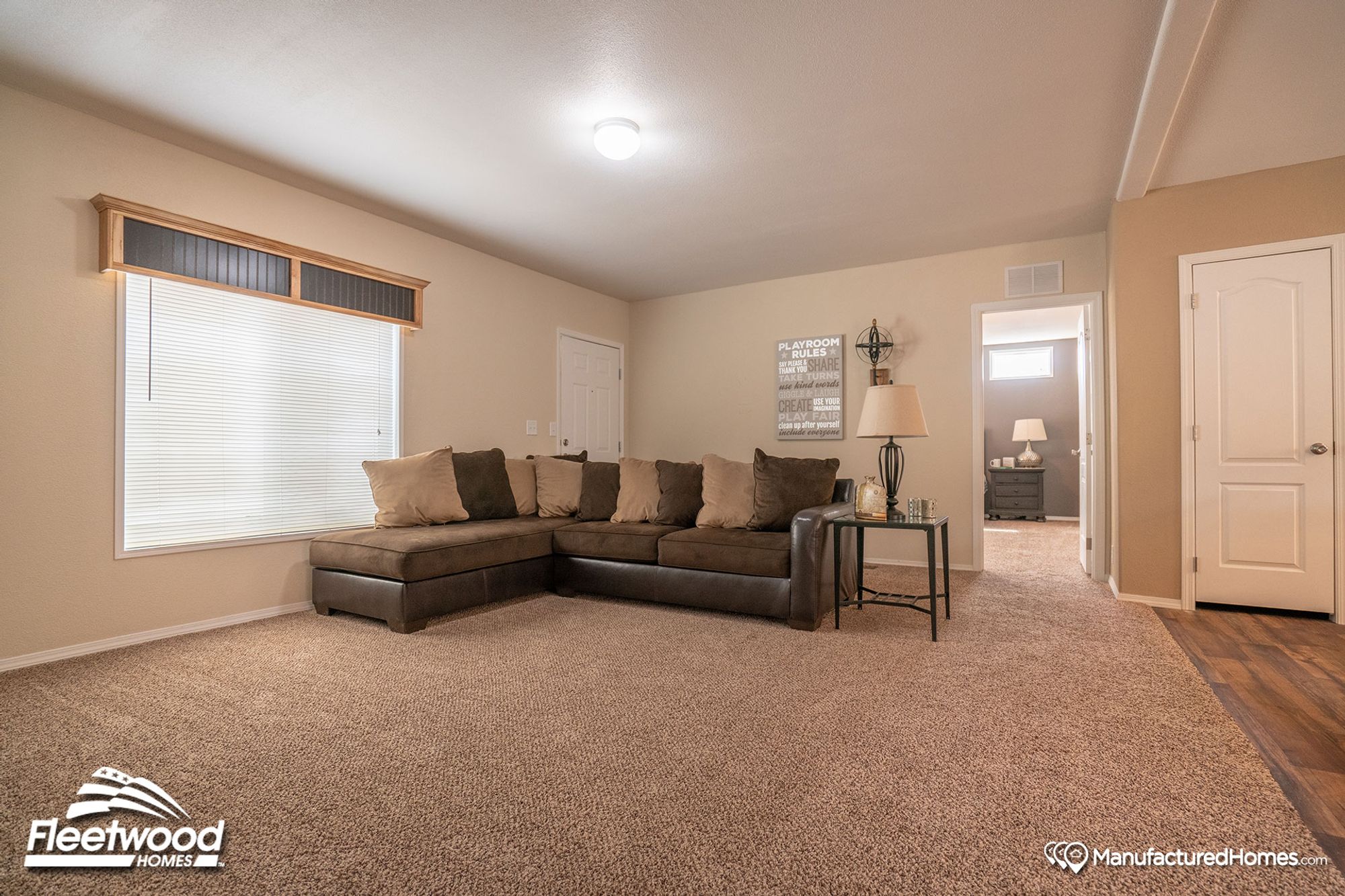 Large open front room with a large couch and a side table.