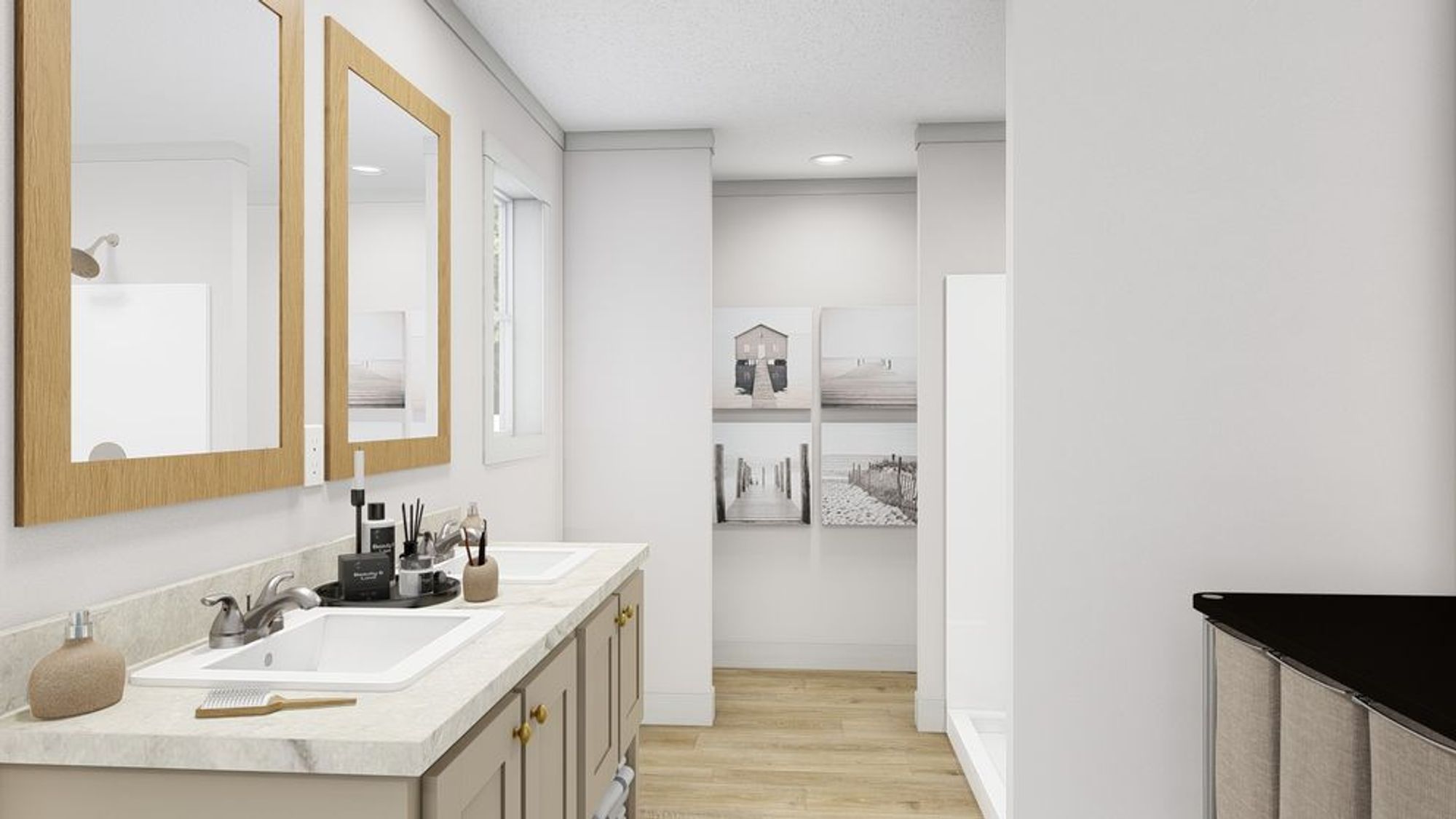 Clean contemporary bathroom with dual vanity, wooden-framed mirrors, white countertops, and view into adjacent hallway with black and white photography.