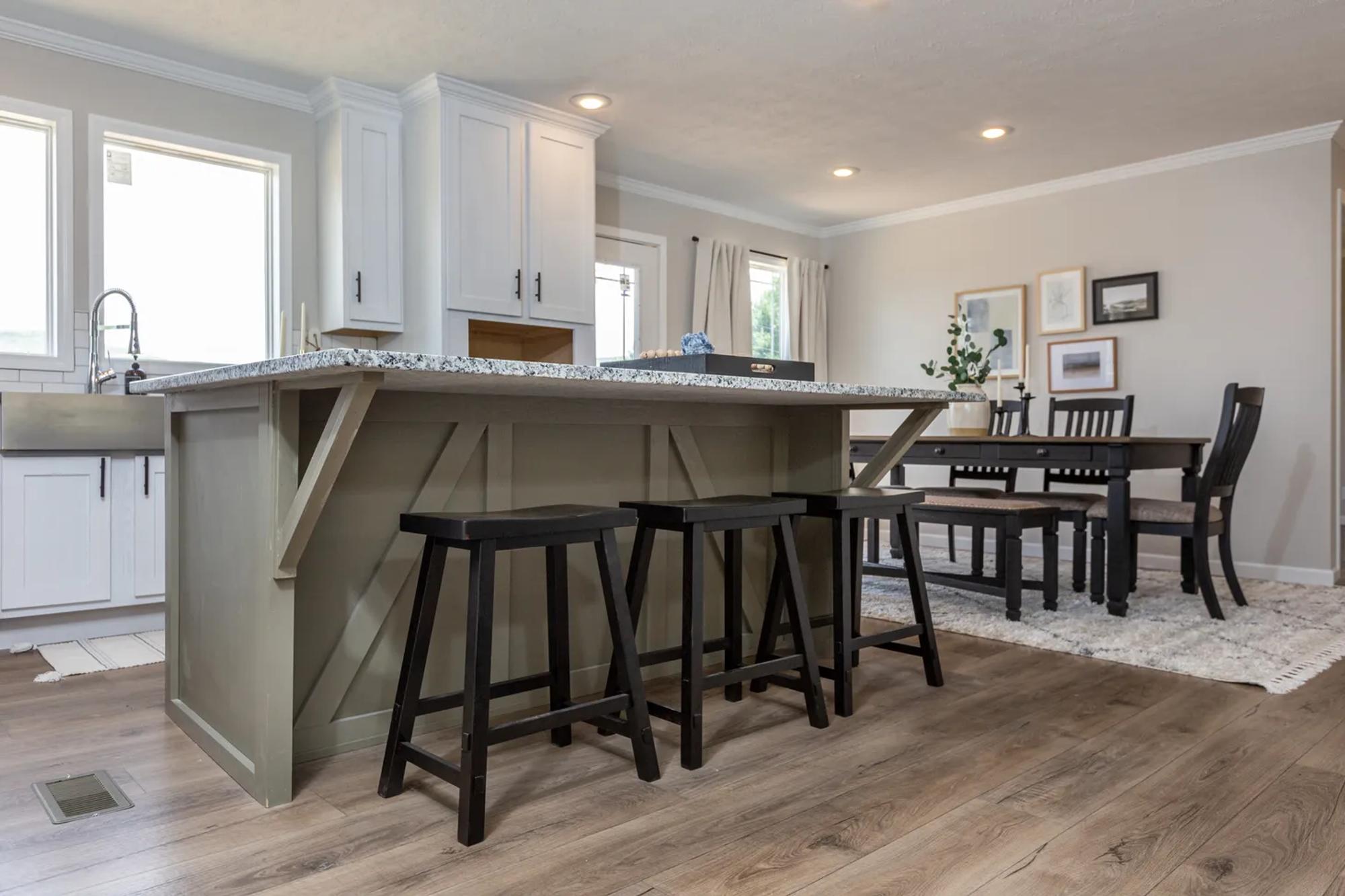 Low view of kitchen and dining room, island with overhang fitting three stools