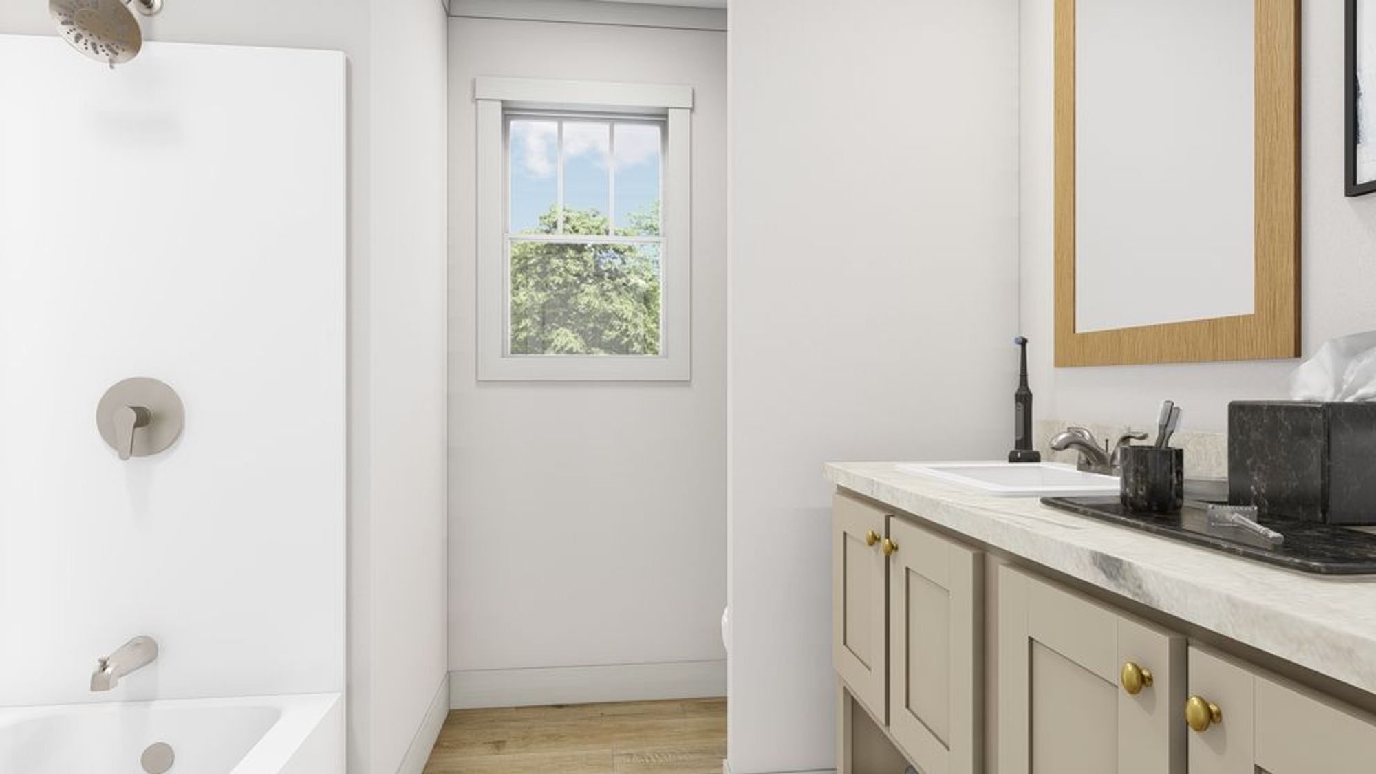 Clean bathroom featuring white vanity with brass hardware, wooden-framed mirror, and natural light from garden view window.