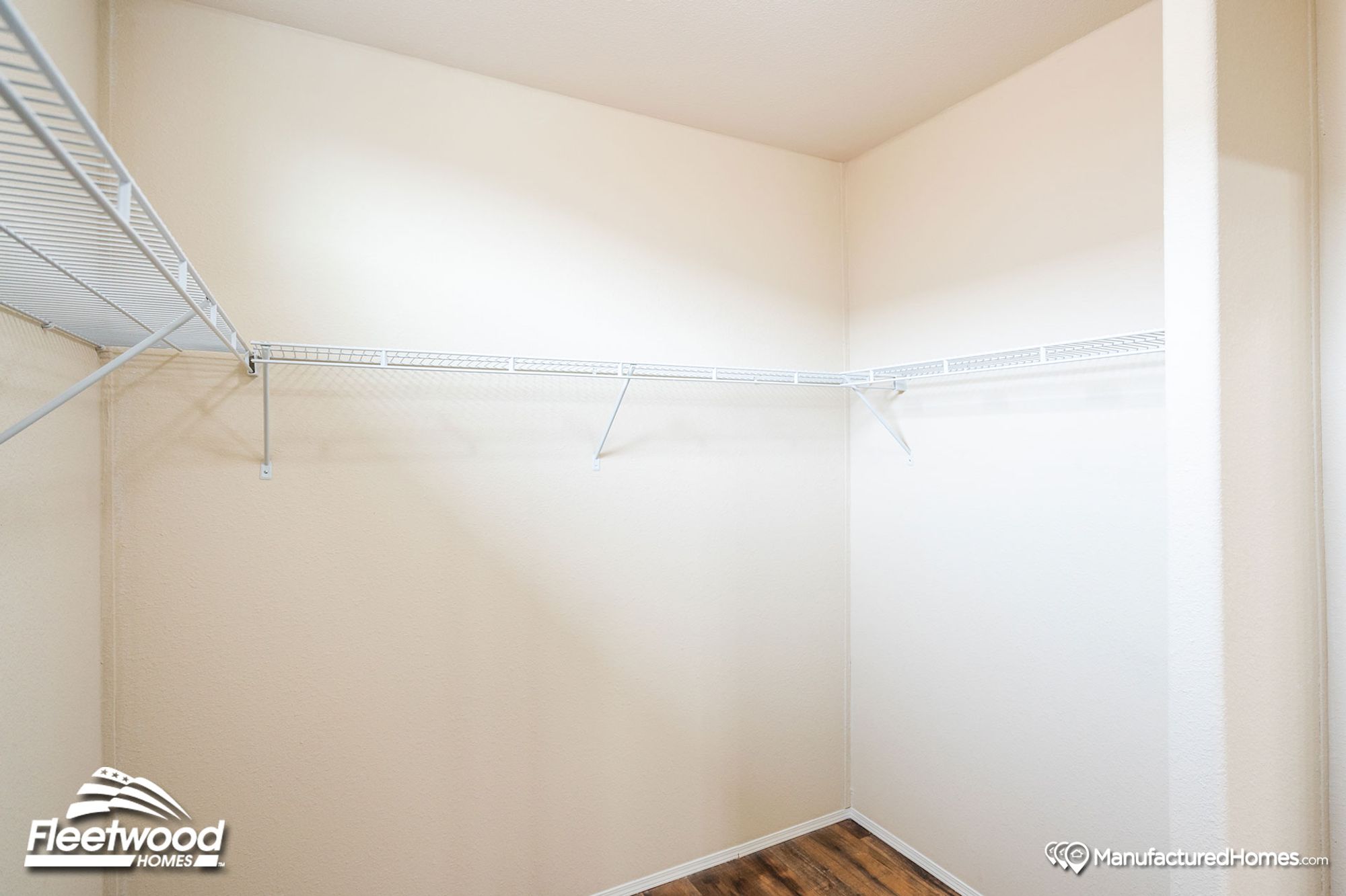 Large walk-in closet with white shelving lining the walls.