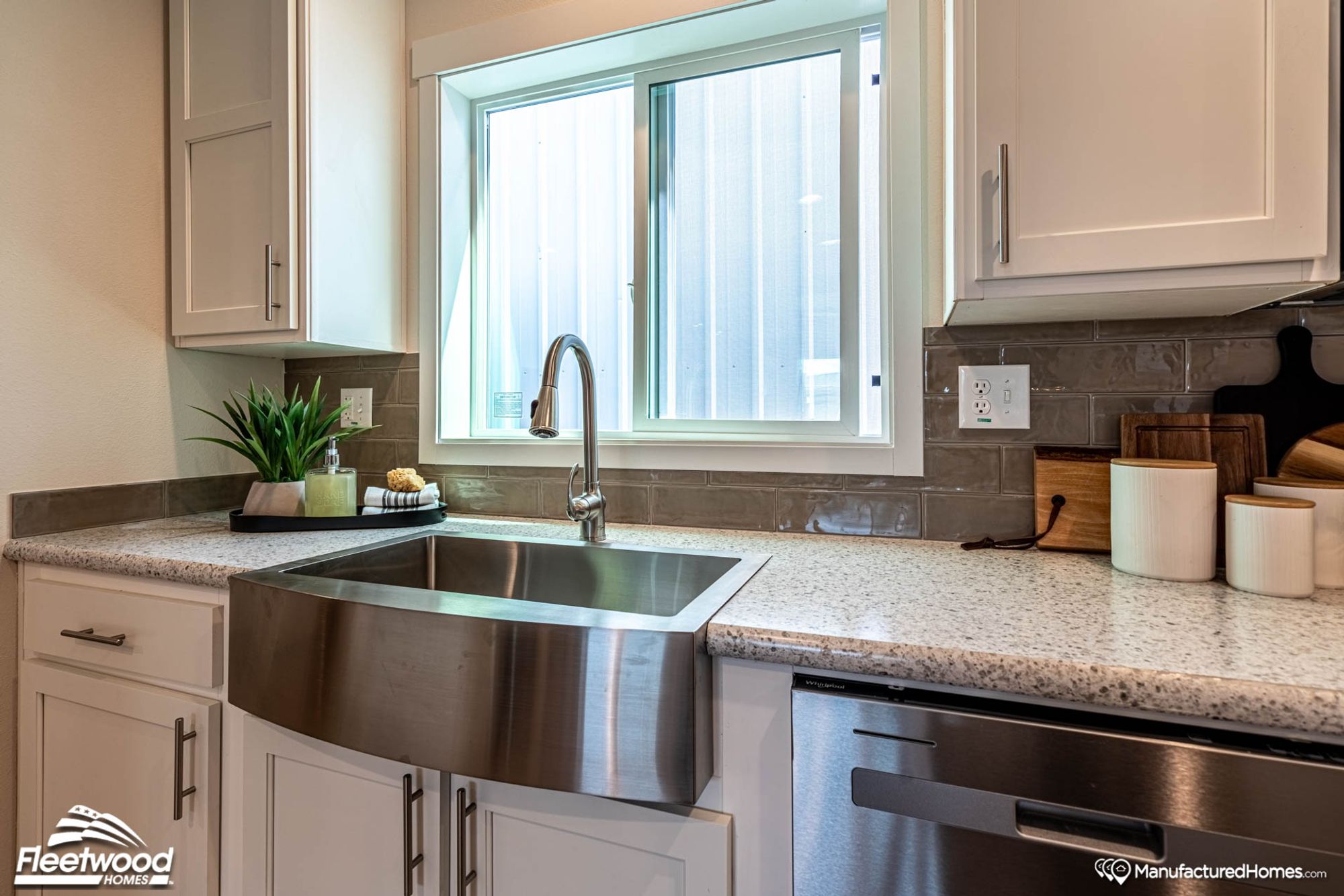 Close up of a kitchen area with a farmhouse sink.