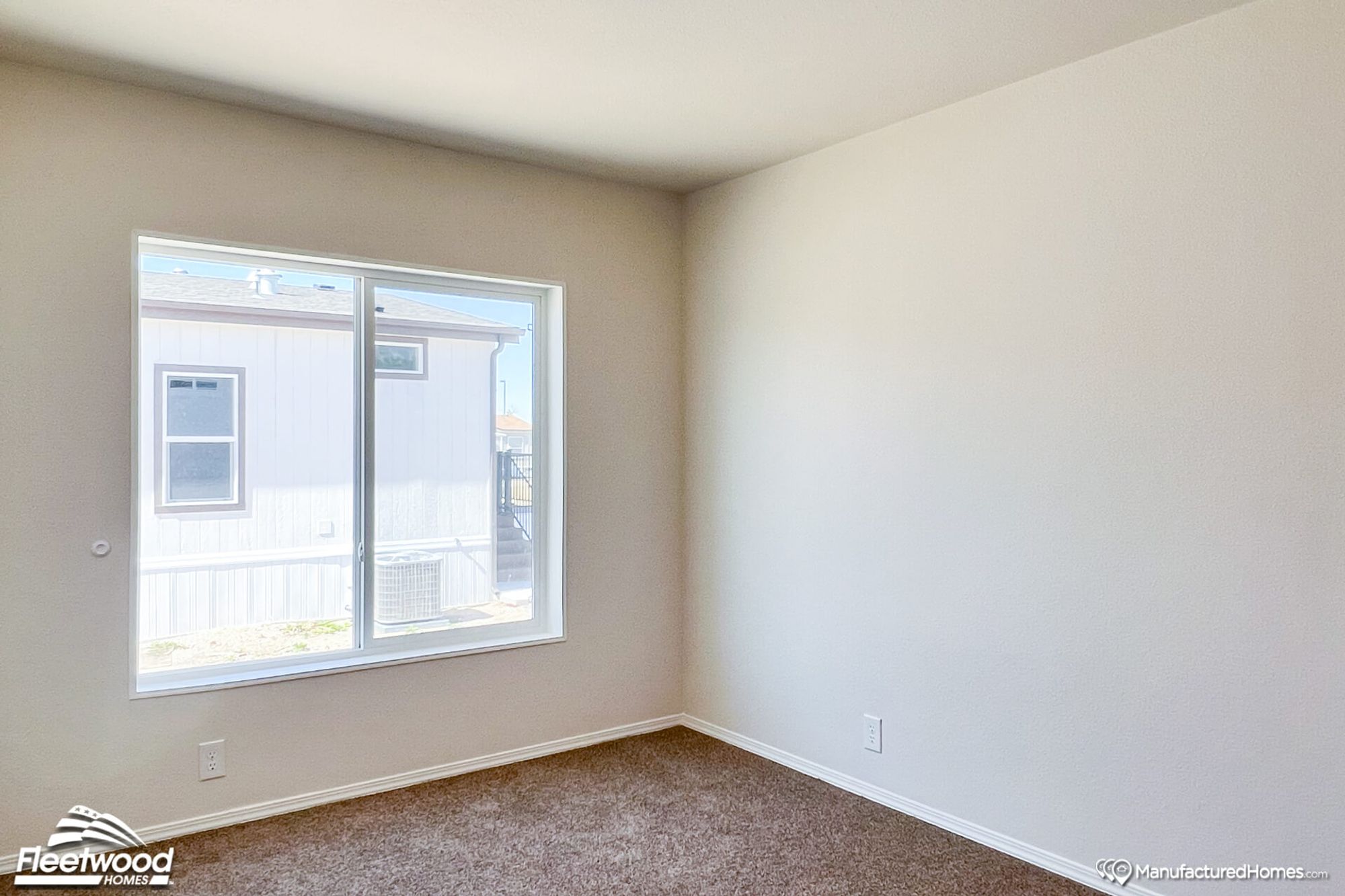 Empty mid-sized bedroom with large windows