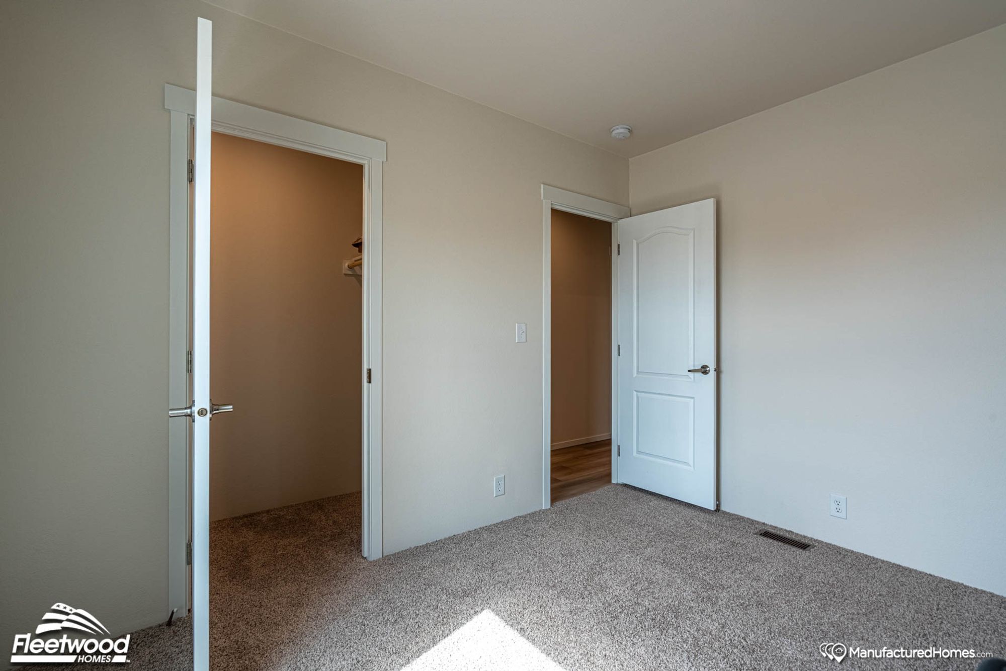 Small empty bedroom with a medium-sized walk-in closet.