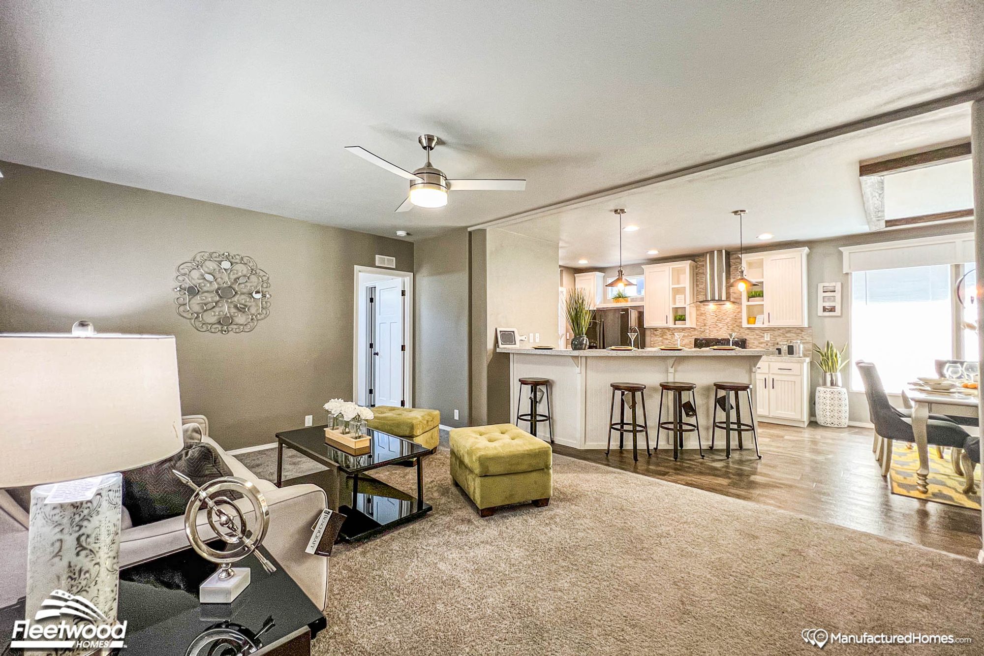 Open concept kitchen, dining room, and living room. The living room is large with a couch and two ottomans.