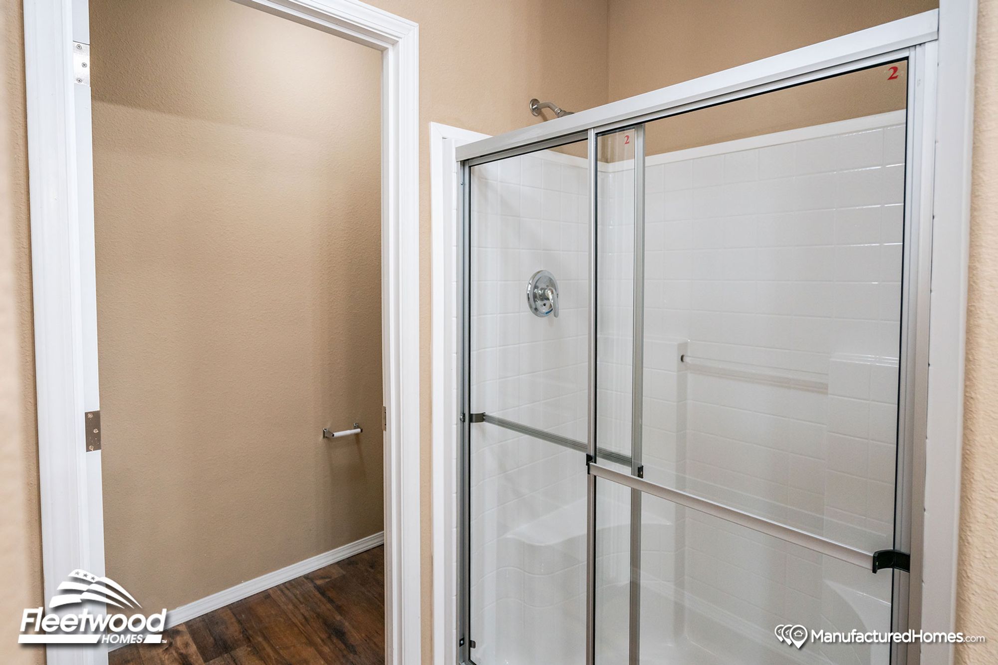 Partial view of a bathroom with a large standing shower.
